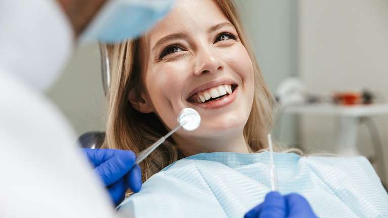 A smiling woman getting a dental exam | Dentist 33510