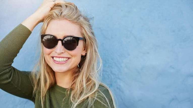 A smiling woman in sunglasses | Brandon Dentist
