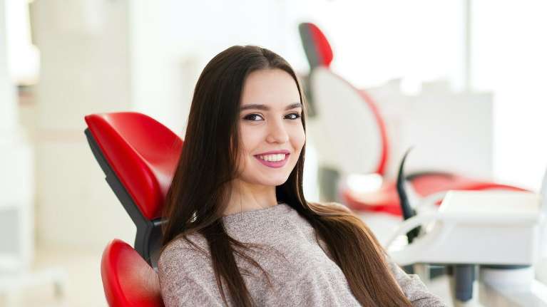 A smiling woman in the dentists' office