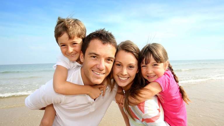 A smiling family on the beach | dentist Brandon FL