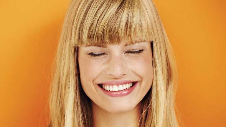 Woman smiling after professional teeth whitening in Brandon, FL