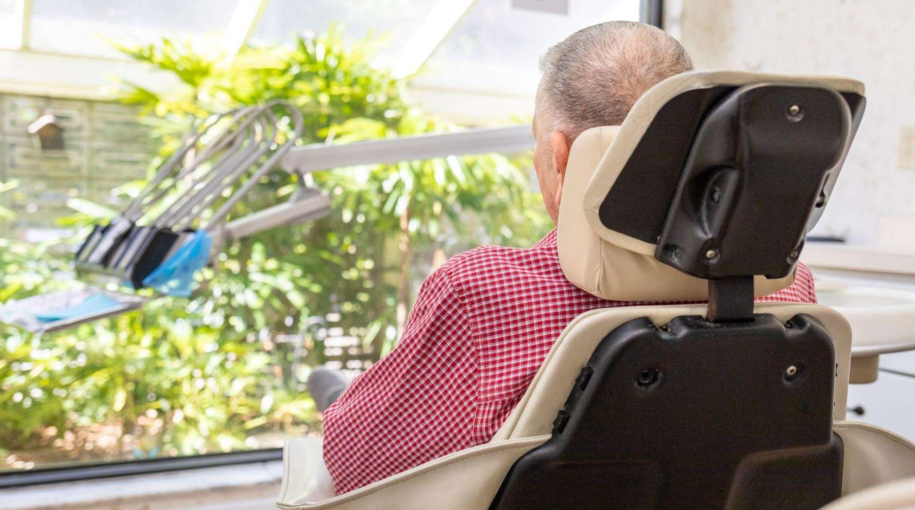 Patient sitting in chair at dentist for dentures in Brandon, FL