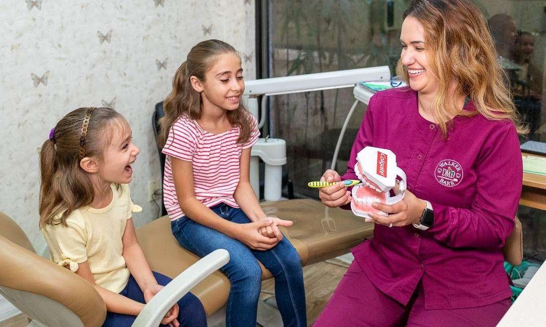 Children's dentist in Brandon, FL showing patients how to brush teeth