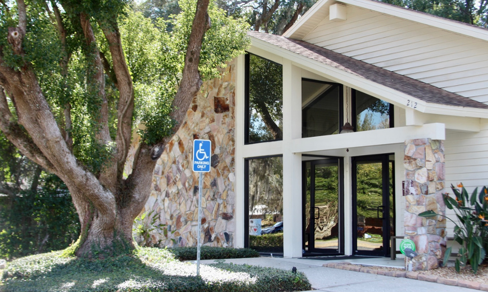 Exterior of McAuley Dental office with stone facade, large windows, and wheelchair accessible parking.